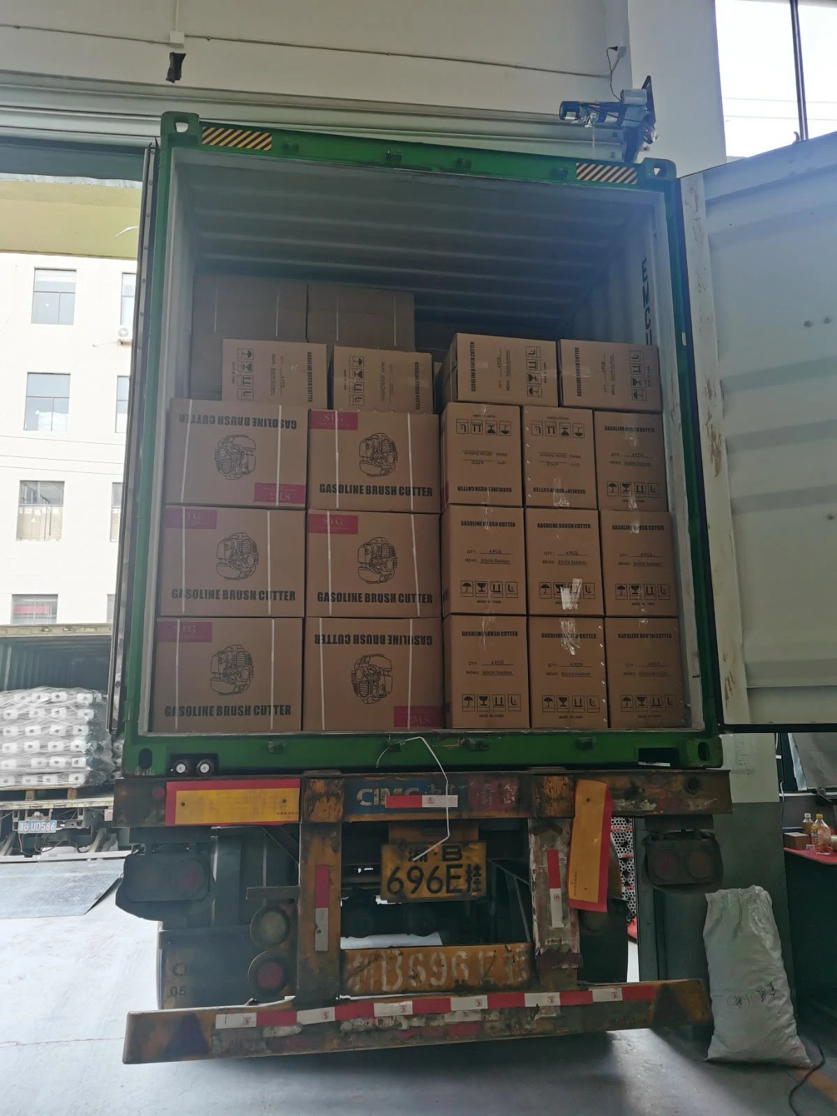 Contêiner sendo carregado com caixas de roçadeiras